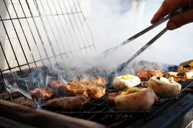 Person grilling with tongs