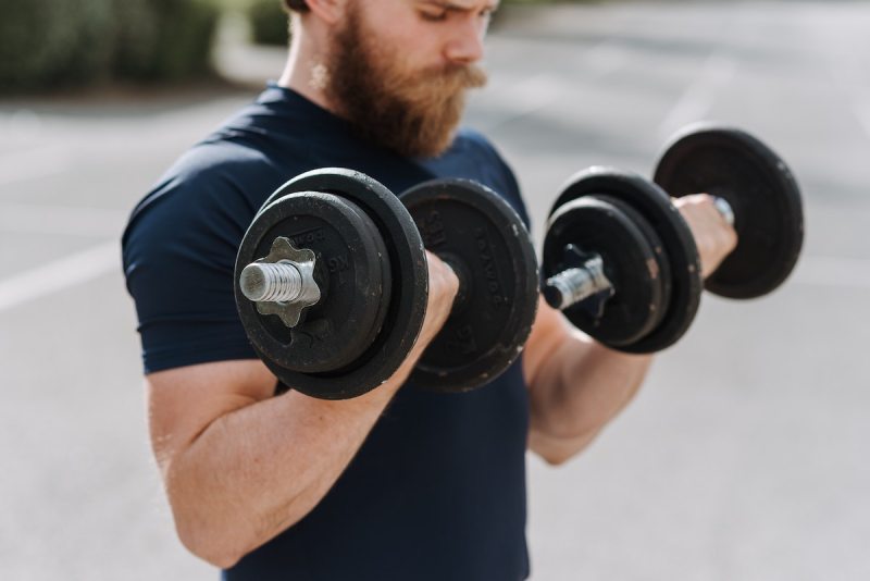 a bearded man doing a biceps curl