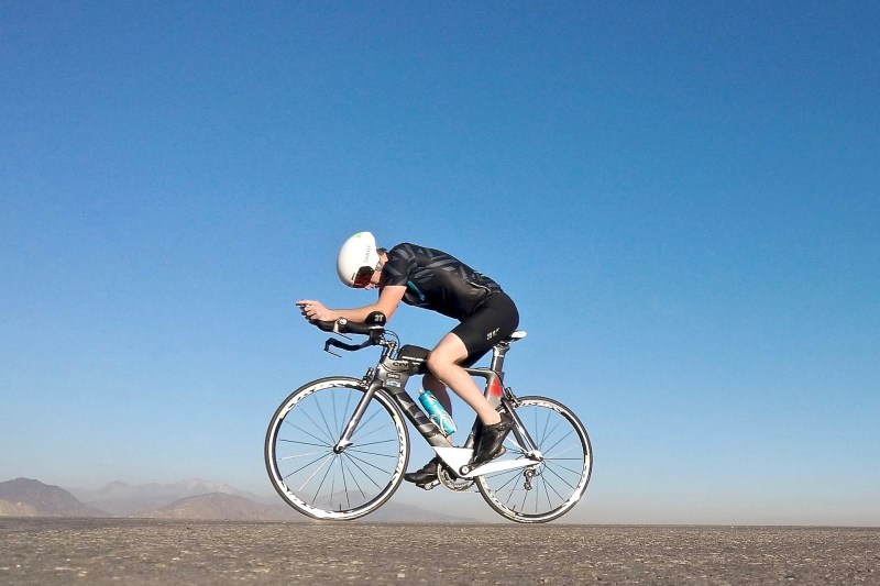 Cyclist balancing on a bike in a barren landscape.