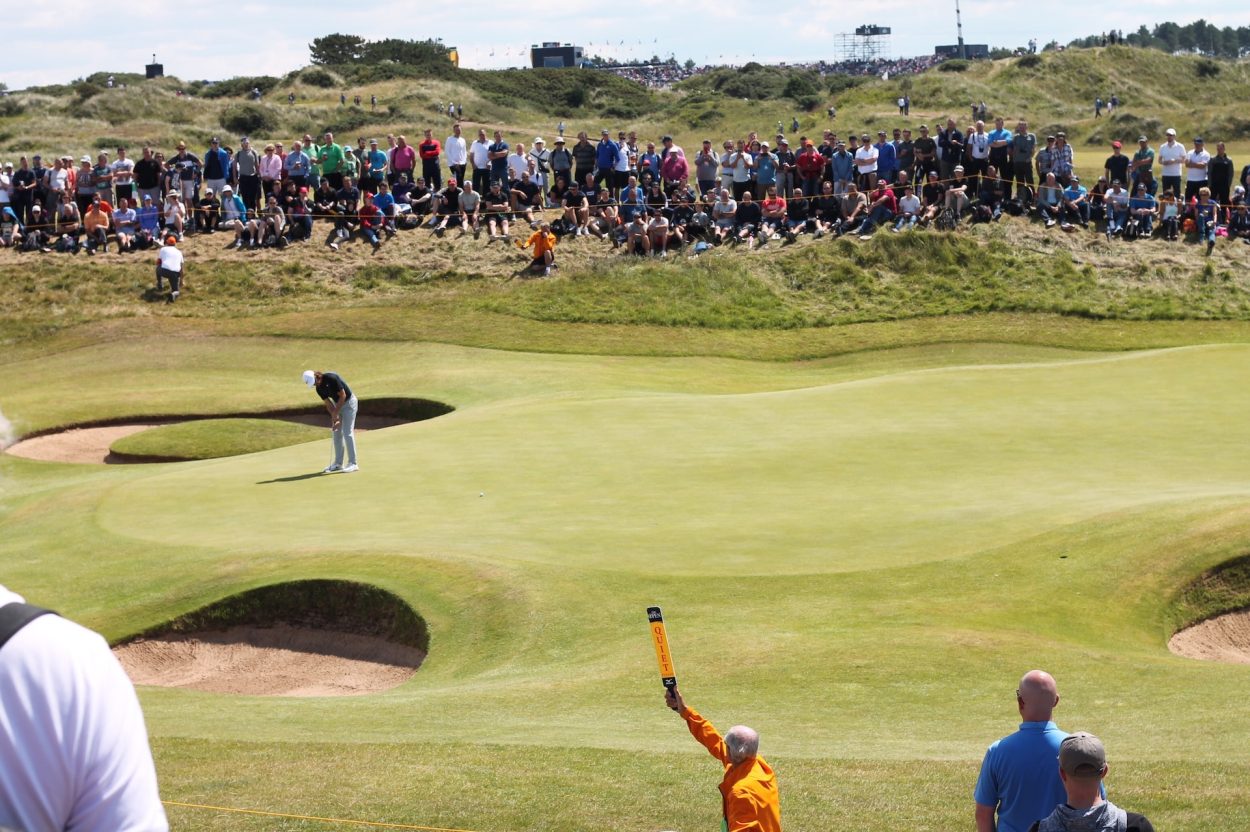 A crowd watching a golfer take a shot.