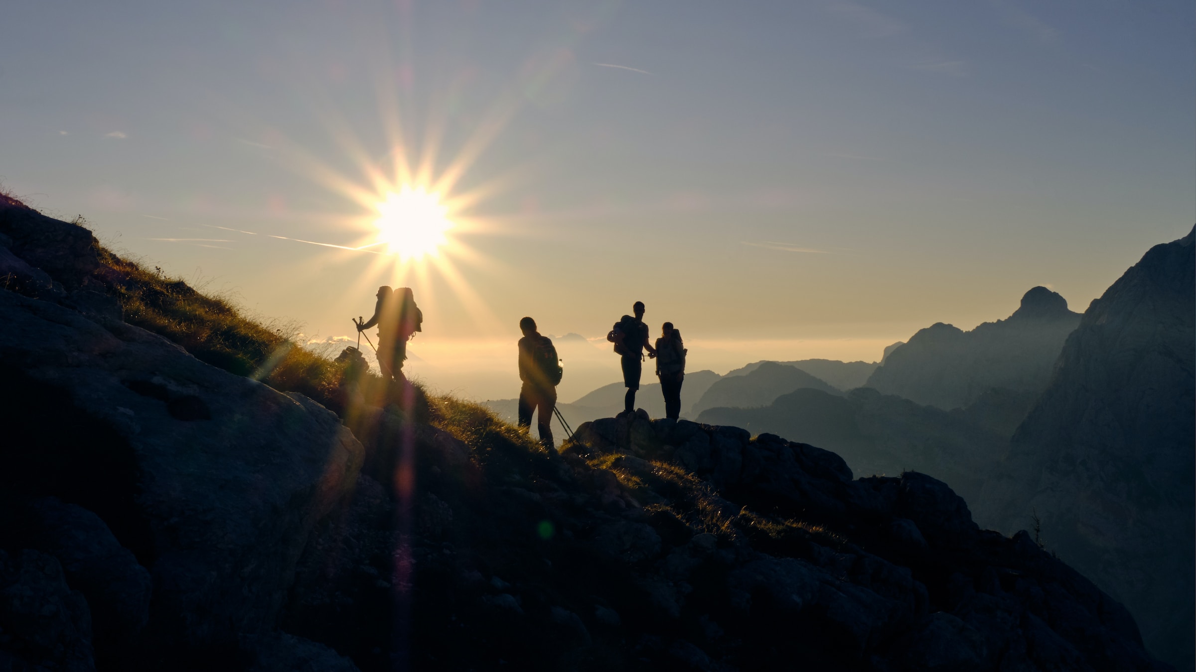 A silhouette of some hikers against the sun