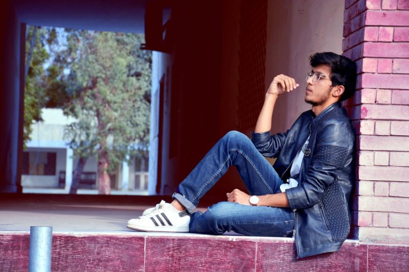 Man sitting wearing cuffed jeans