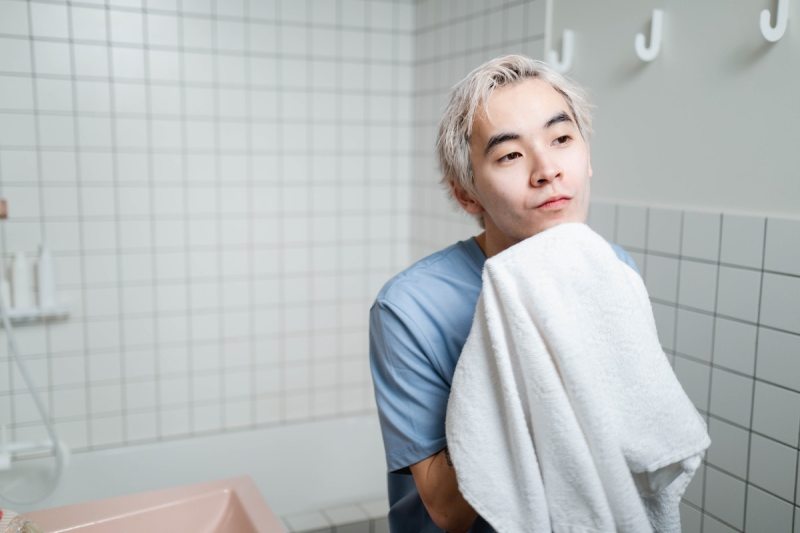Young man drying his face