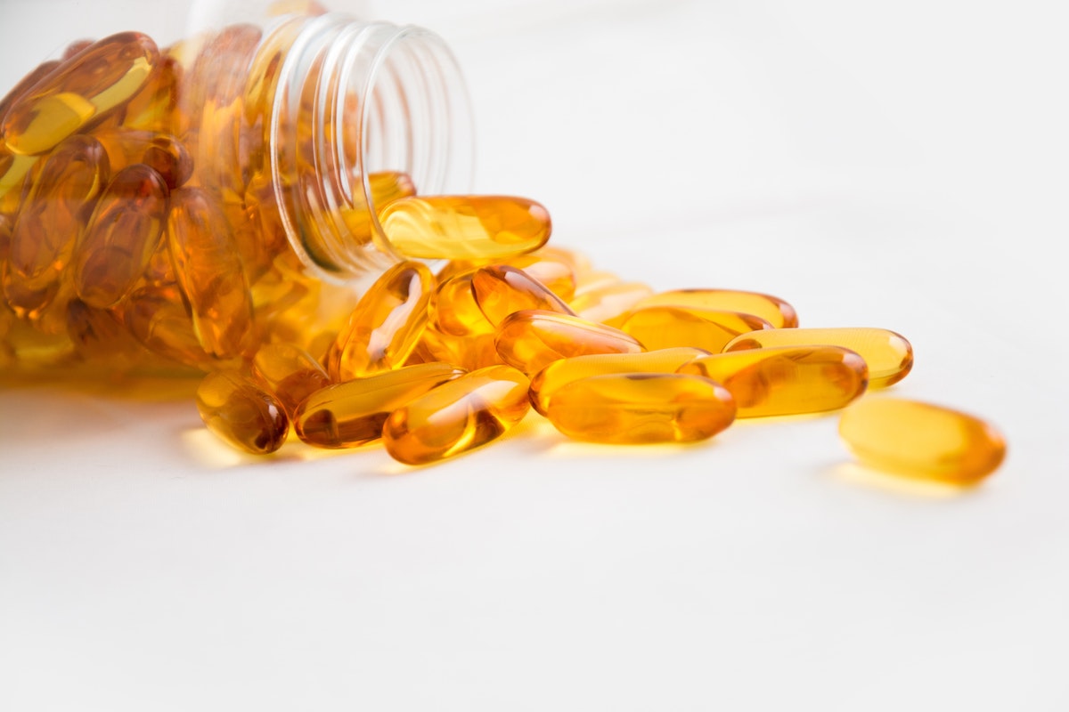 a bottle of orange supplements against a white background