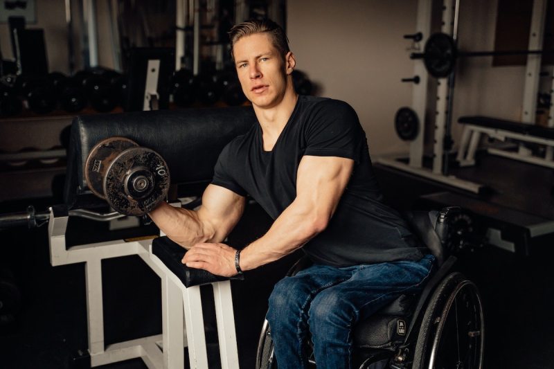 a man in a wheelchair performing a biceps curl