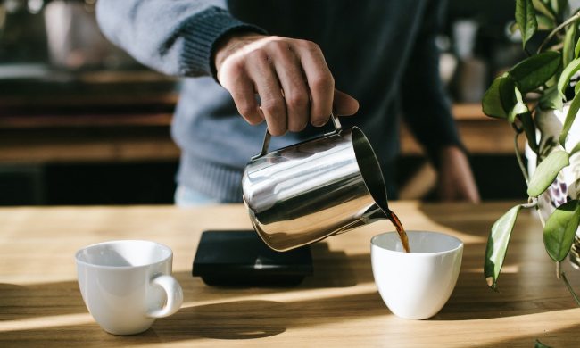 Man in blue sweater making cup of coffee