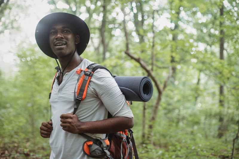 Man wearing hat and hiking outdoors