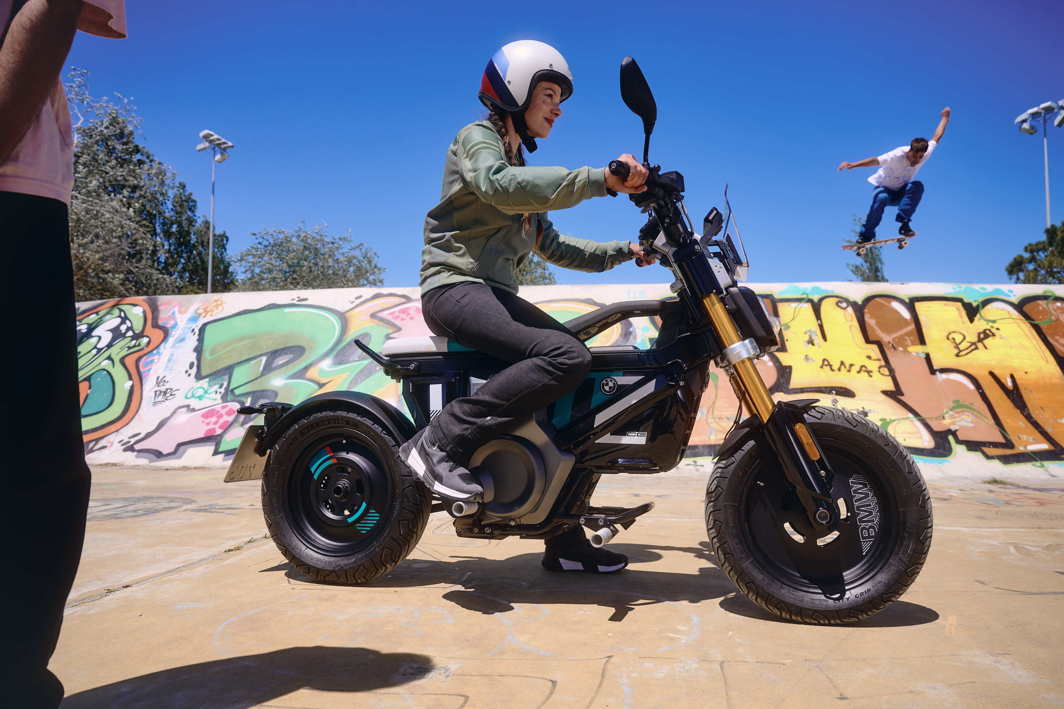 A person riding the BMW CE 02 in what appears to be a skate park