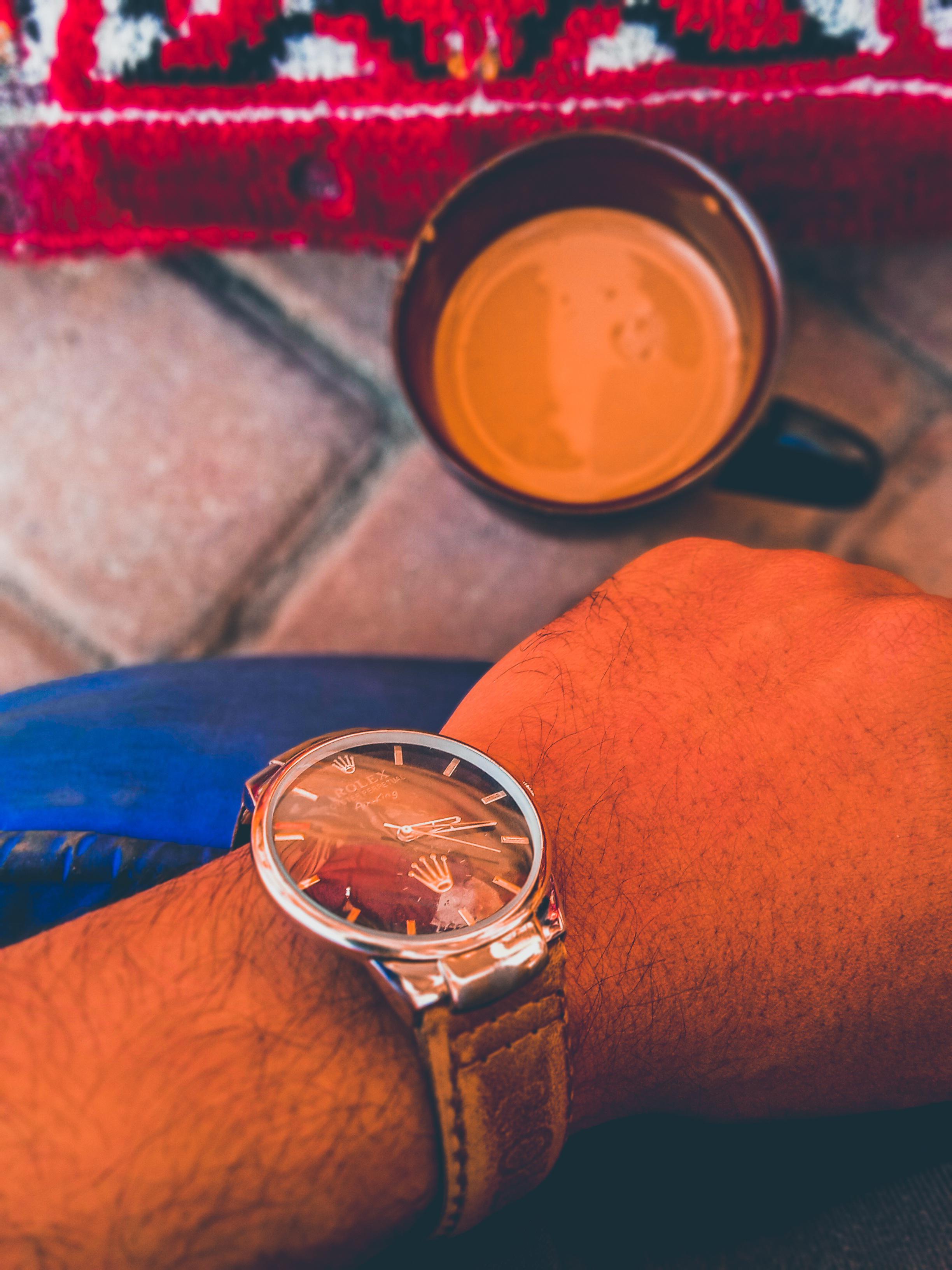 A man wearing a Rolex with what appears to be a tropical dial