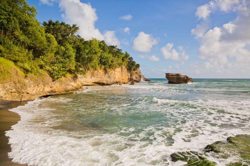 Waves lapping the small black sand beach at Anse Balenbouche in St. Lucia.