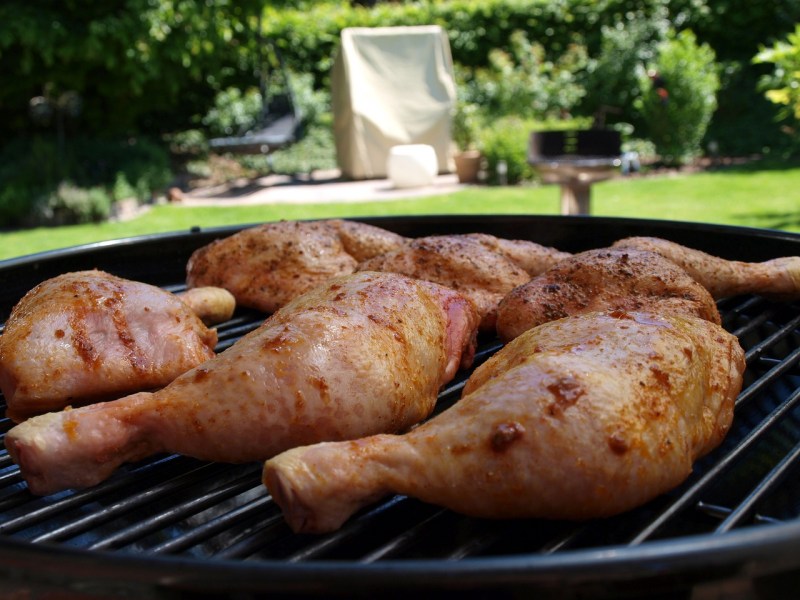 Raw chicken legs on grill