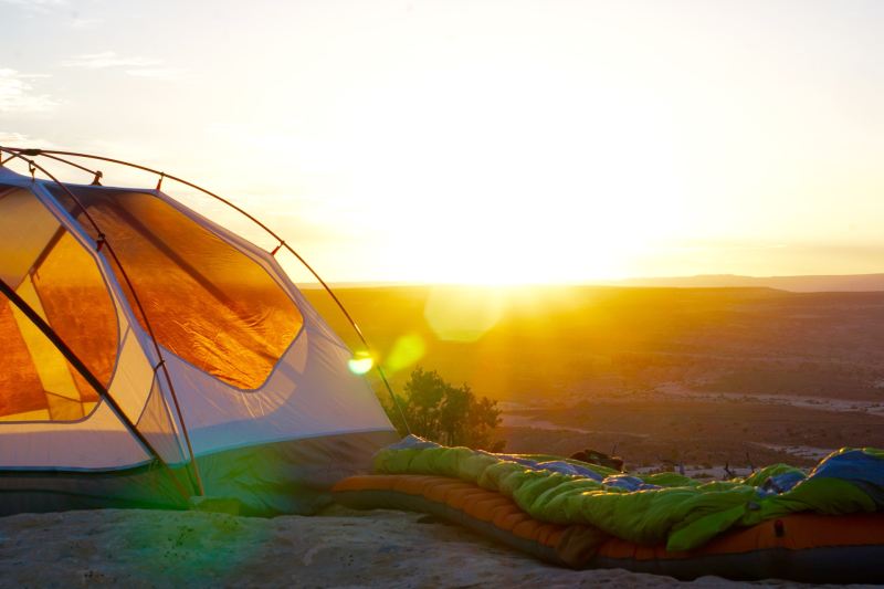 A tent set up as the sun rises.