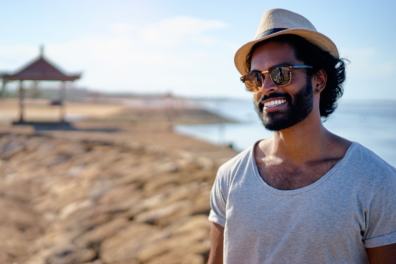 Man with a beard standing on the beach.