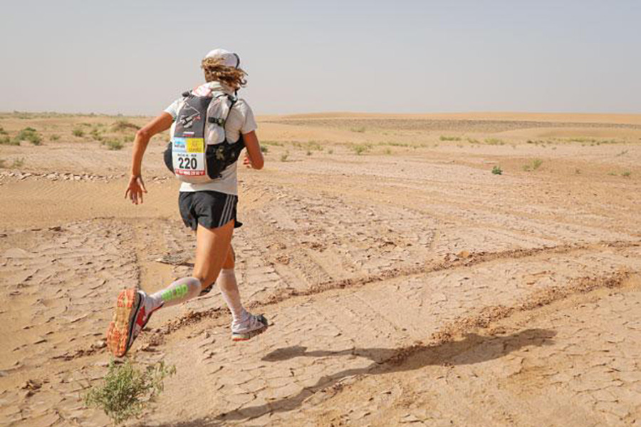 Person running across the desert in Africa's Marathon des Sables endurance race.