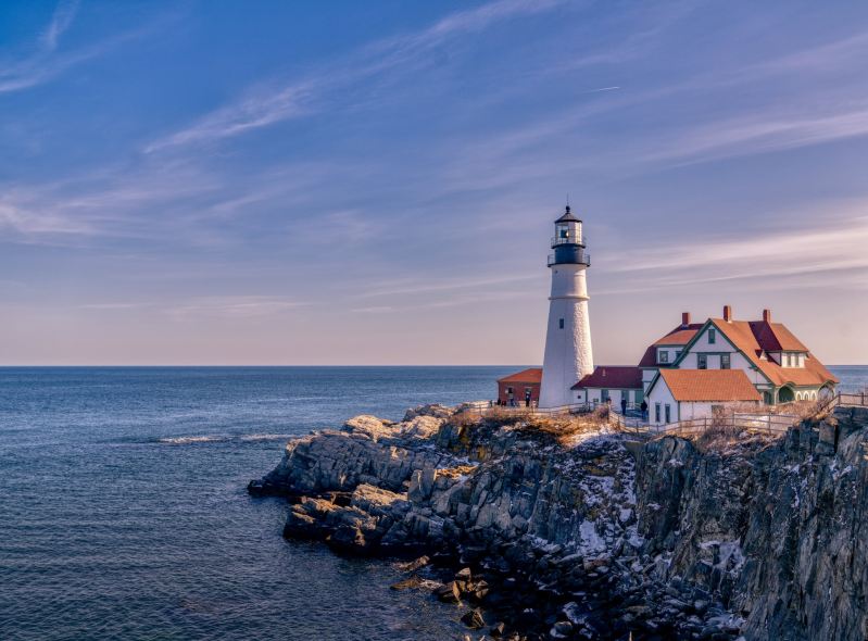View from the water of Maine's Portland Head Lighthouse at sunset.