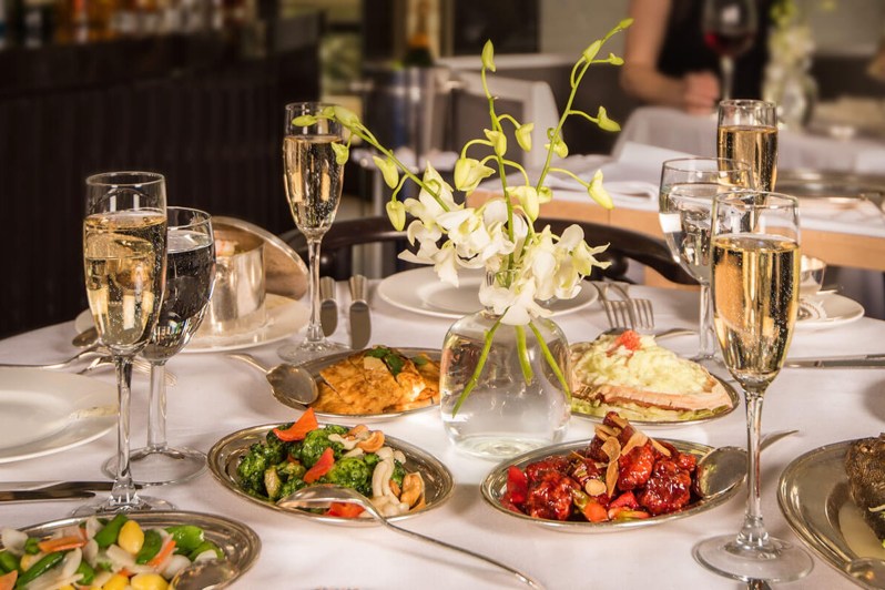 A dining room table with plates full of food at Mr. Chow at Caesars Palace Las Vegas.