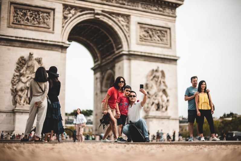 Tourists in France taking pictures in a busy spot.