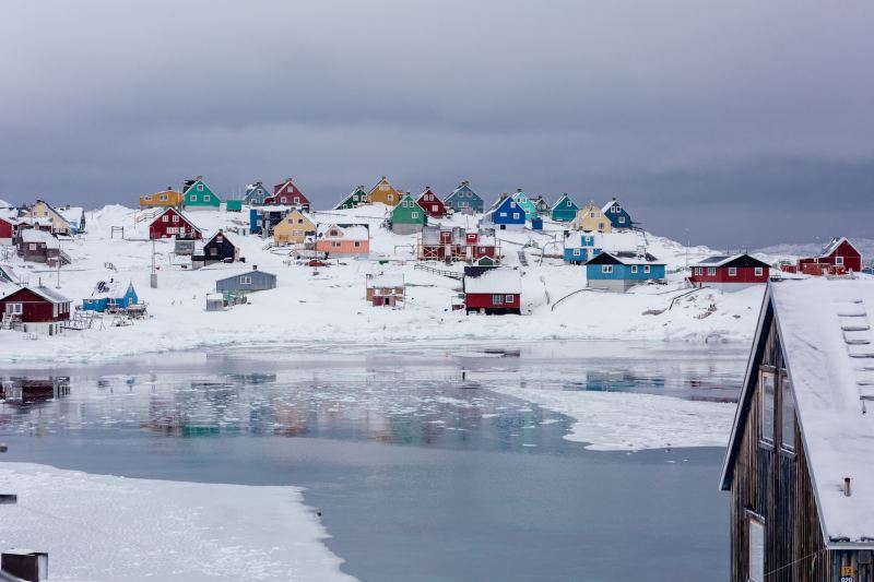 Colorful homes in an icy landscape in the town of Aasiaat Greenland during winter.