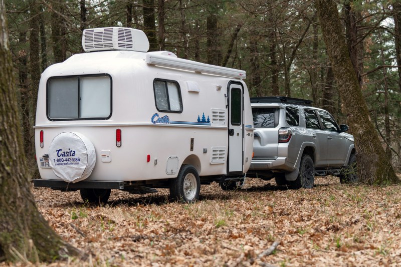 Silver Toyota 4Runner towing a Casita Freedom Deluxe travel trailer in the woods.