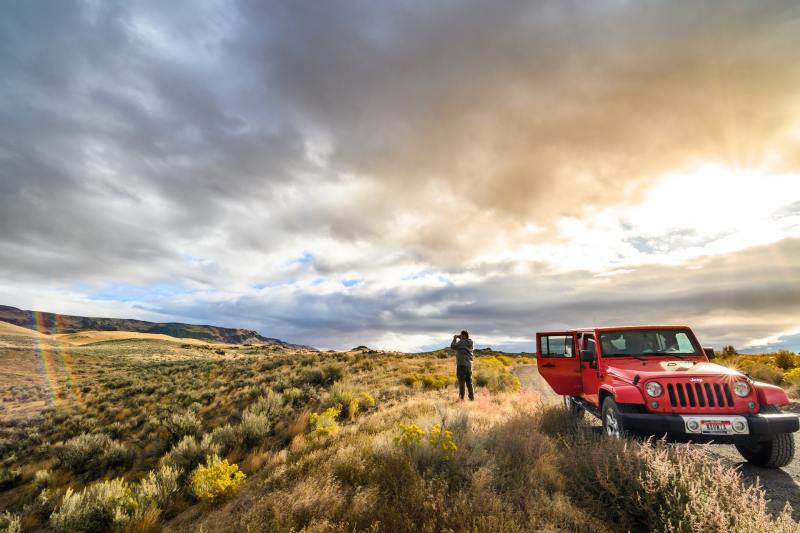red jeep parked on scenic mountainside