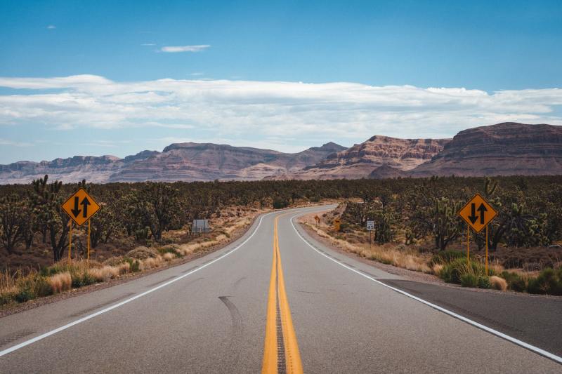 a stretch of highway with mountains in the background
