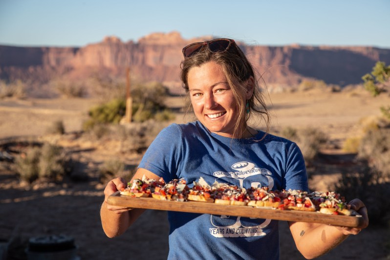 A woman holding food for guests on an Escape Adventures trip