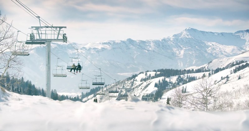 A chairlift heads up a mountain promoting Ski Butlers.