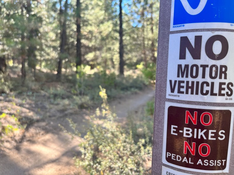 A "no e-bikes" with the trail in the background
