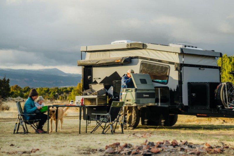 Small family relaxing outdoors with a Boreas Campers EOS-12 camper trailer.