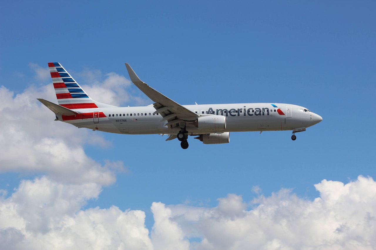 An American Airlines plane in flight with clouds in the background