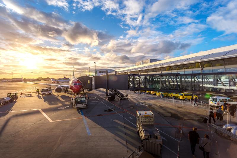 An airport from the exterior, showing an airplane connected to the terminal