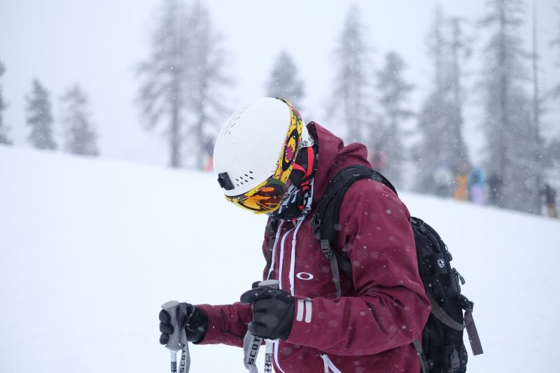 A man standing on the mountain wearing ski gloves.