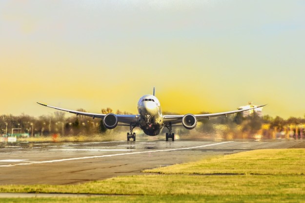 airplane taking off on a runway at sunset