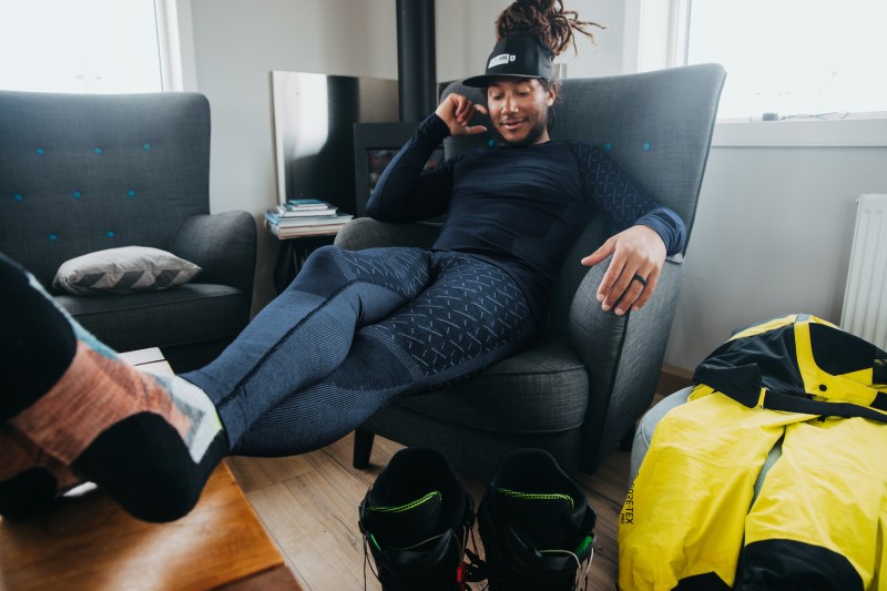 A man sits in a chair wearing the ODLO x Burton Slokar Baselayers