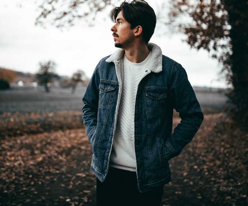 Man wearing denim coat in the woods