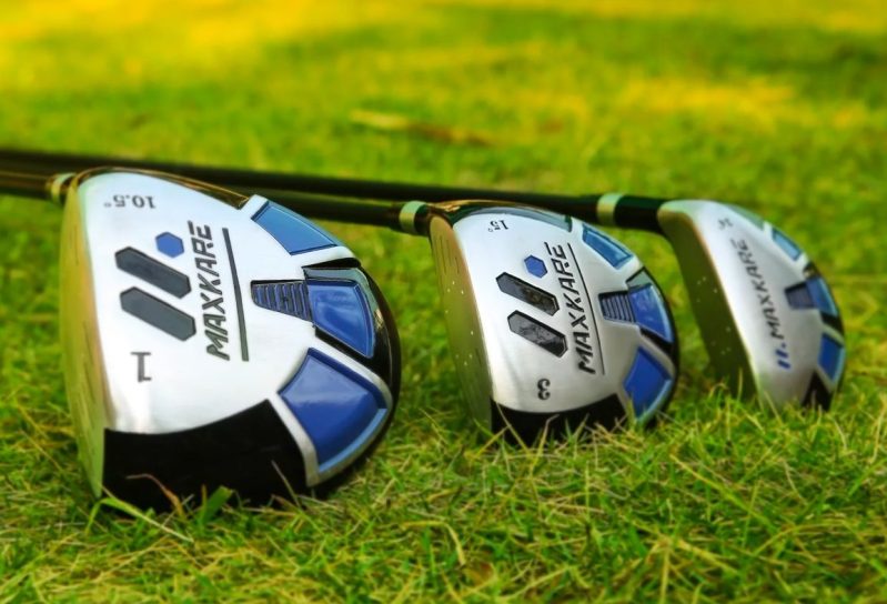 The MaxKare driver, 3-wood, and hybrid club laid out on the grass.