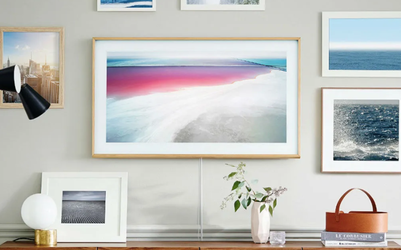Samsung's The Frame on a wall surrounded by paintings and docarations