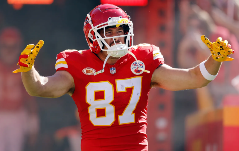 Travis Kelce on the field in his trademark Kansas City Chiefs jersey, complete with helmet.
