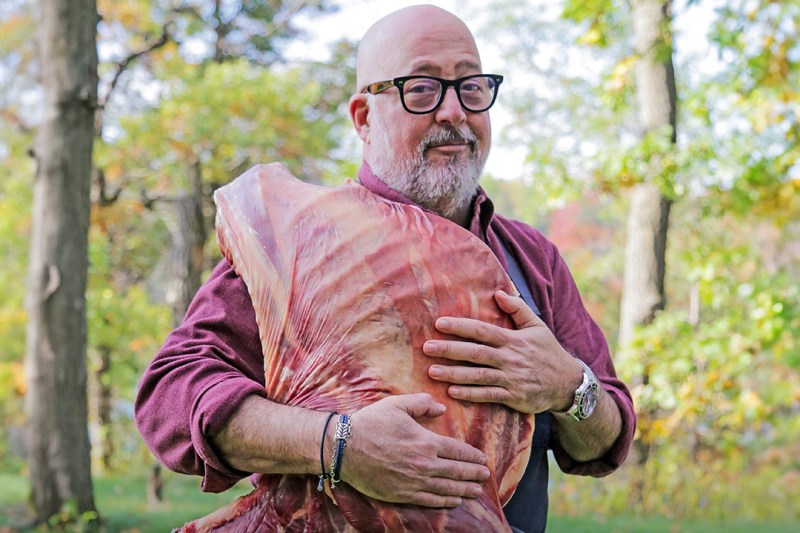 Andrew Zimmern holding meat.