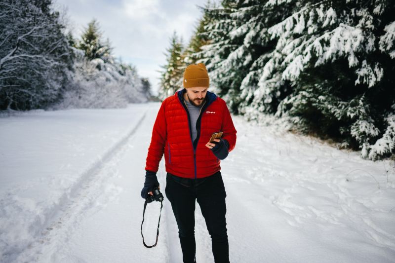 Man using phone in the snow.