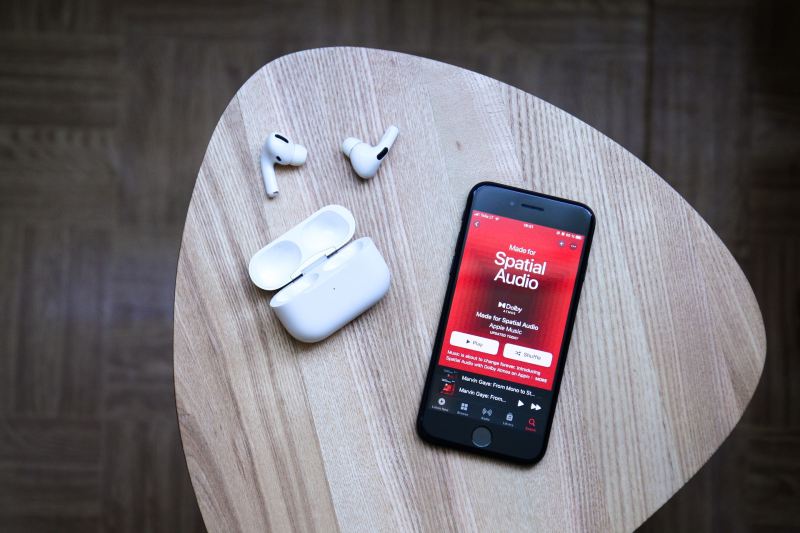 An iPhone with airpods sitting on a table.