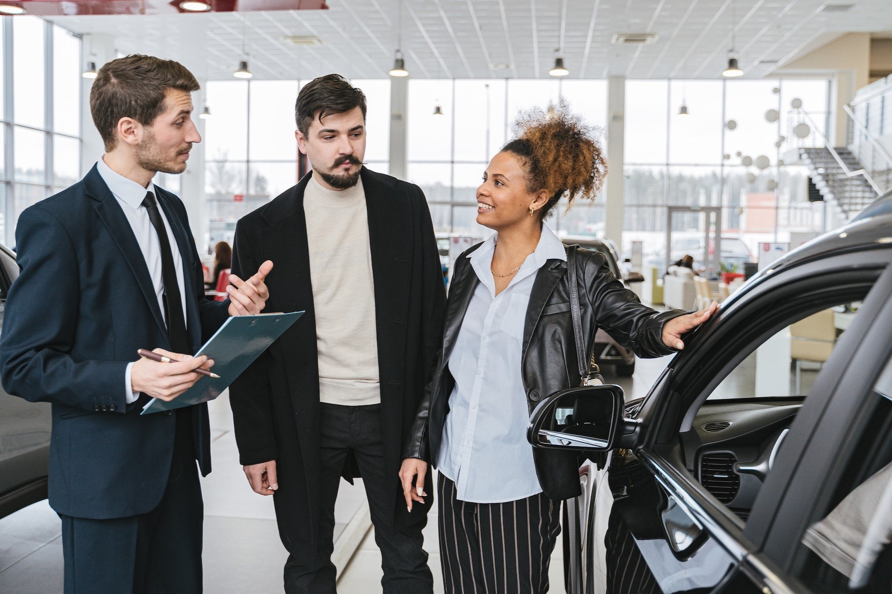 People having a conersation at a car dealership