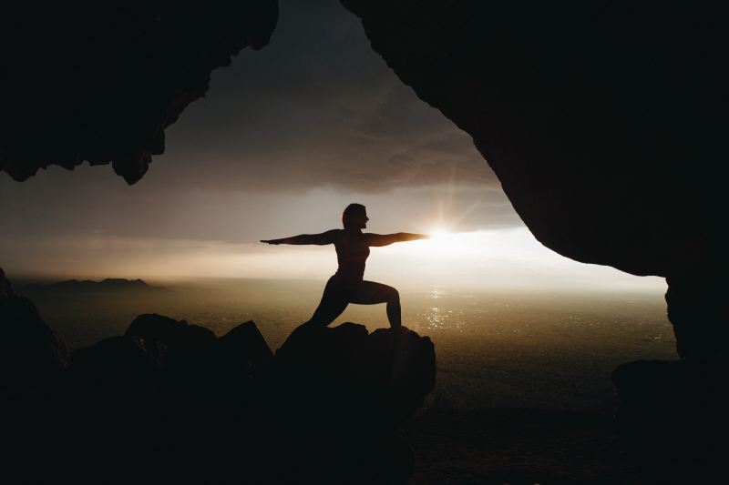 Silhouette yoga pose on a clifftop
