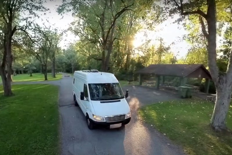 YouTuber DualEx's Mercedes Sprinter conversion campervan driving through a park.