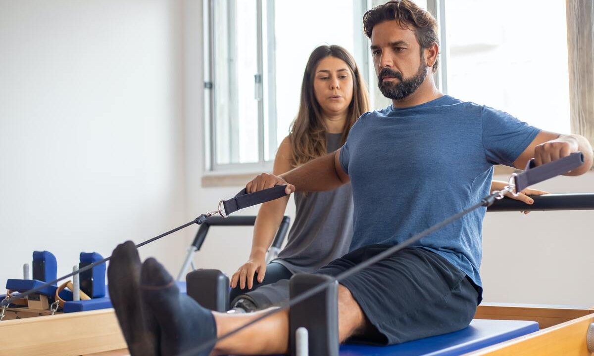 Man using Pilates reformer.
