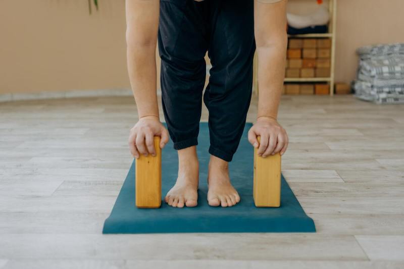 Man doing Pilates with yoga blocks.