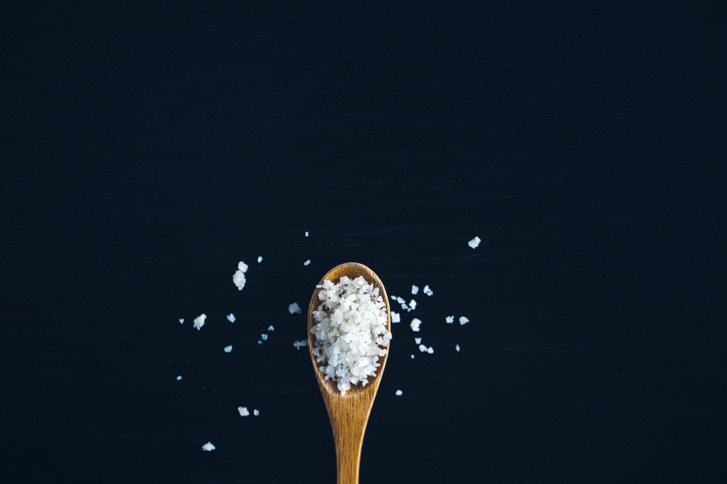 Wooden spoon with large flakes of salt