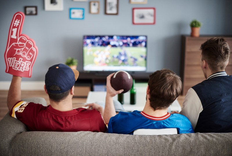 Three men with American football equipment