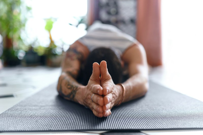 Horizontal view of man's folded hands while doing pilates