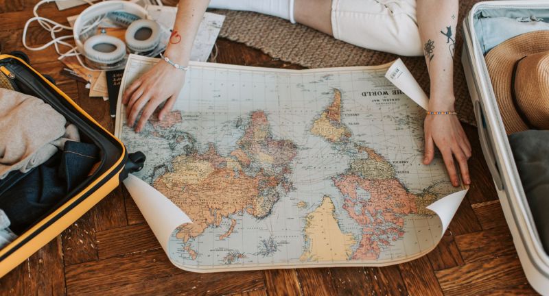 Person sitting on floor with world map